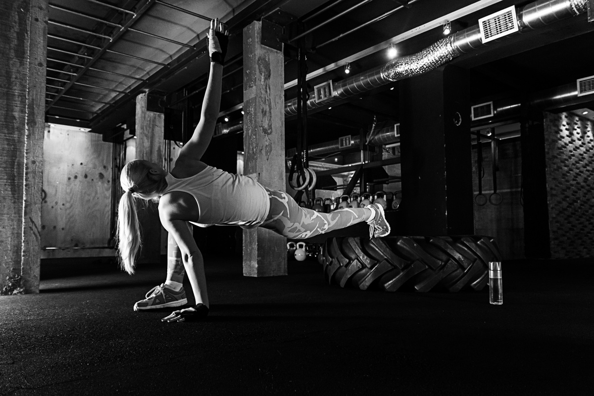 Exercising with tyre. Black and white fitness women